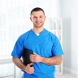 Male nurse smiling standing in a hallway